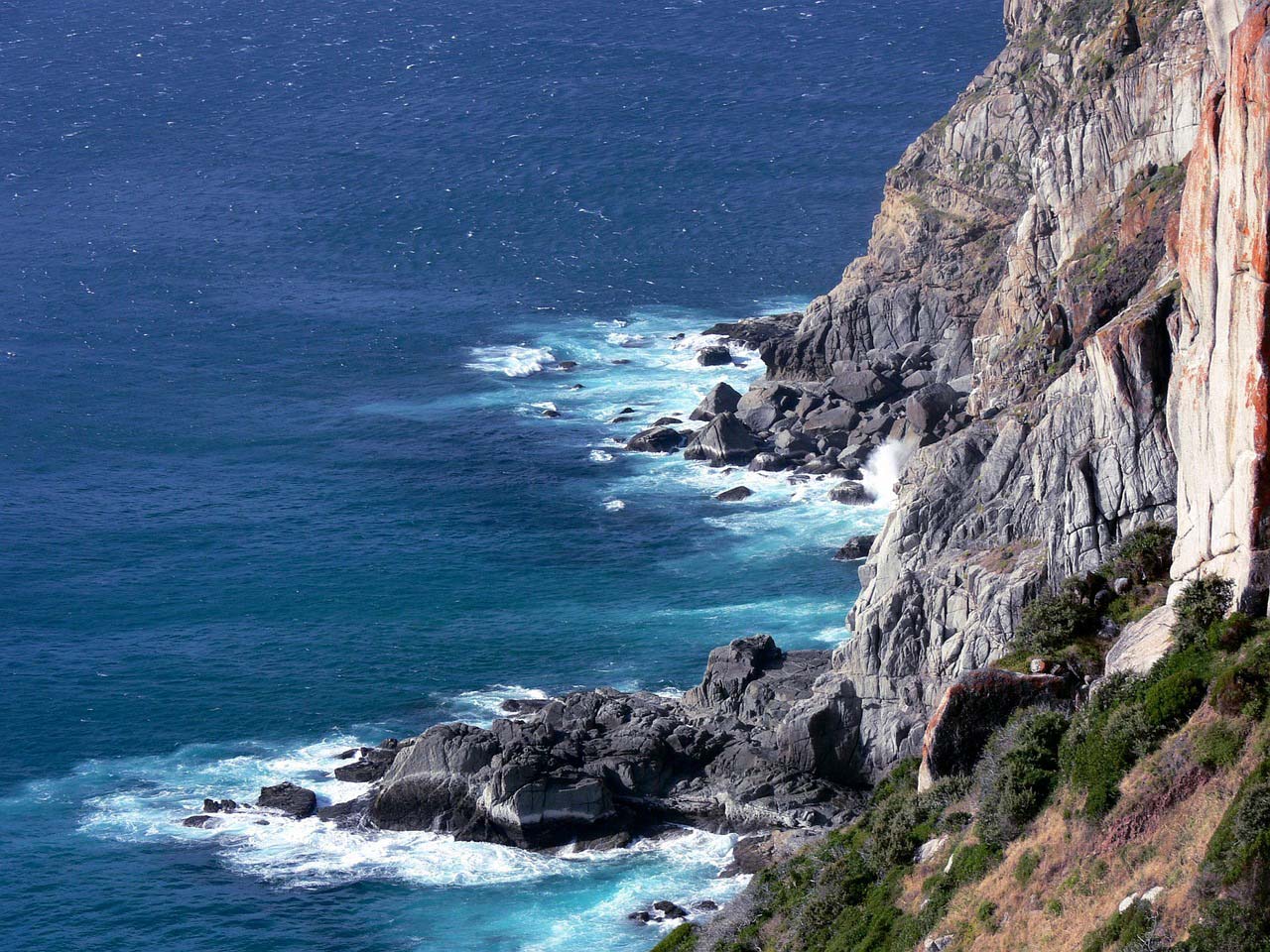 Photo of the ocean and shore with mountains